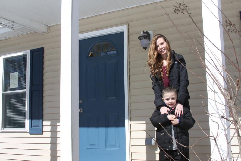 Victoria Swank and her son Brian Santiago stand in front of their new, Habitat for Humanity-built home on Sunday. BY MATTHEW BERNAT